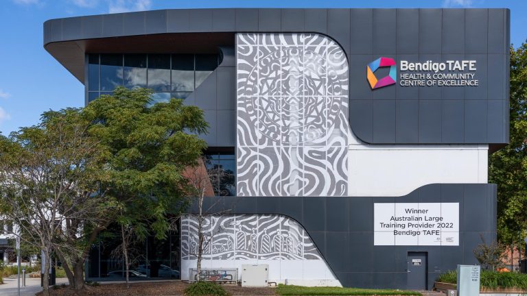 Exterior view of the Bendigo TAFE Health & Community Centre of Excellence at the City campus, a dark grey, modern building