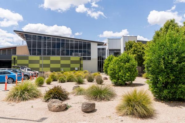 Exterior view of a contemporary building at Bendigo TAFE Echuca campus with large, sloped windows and green/olive checkered panels